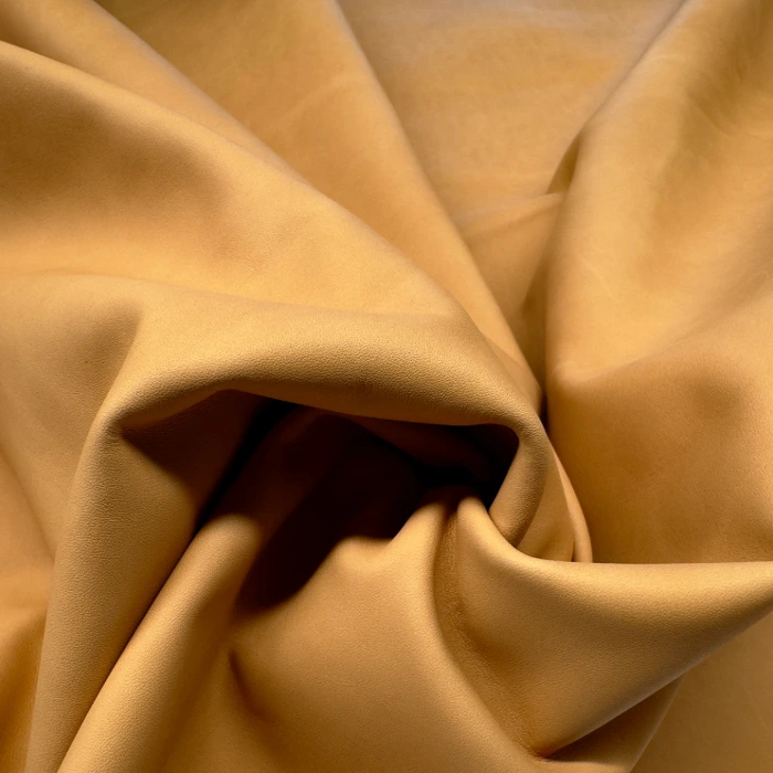 Light brown leather being twisted and folded