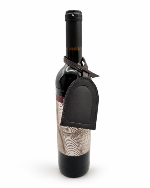 Wine bottle with a leather tag in a white backdrop